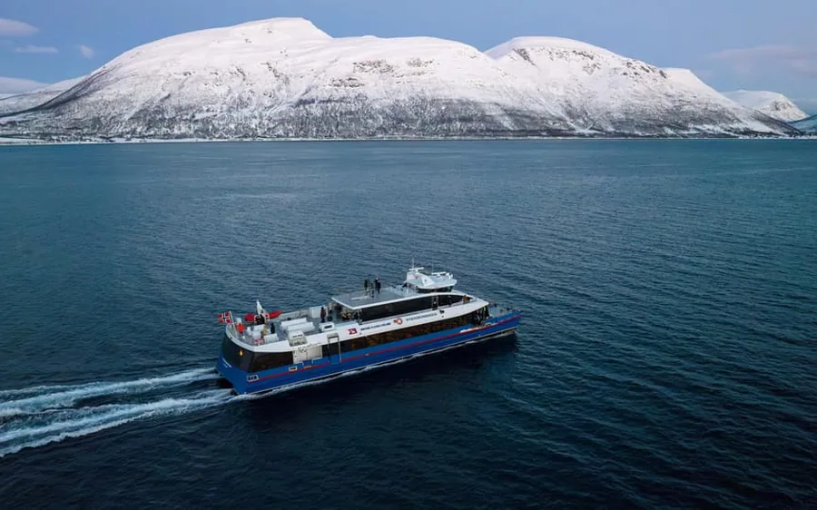 A catamaran against snow-covered mountains