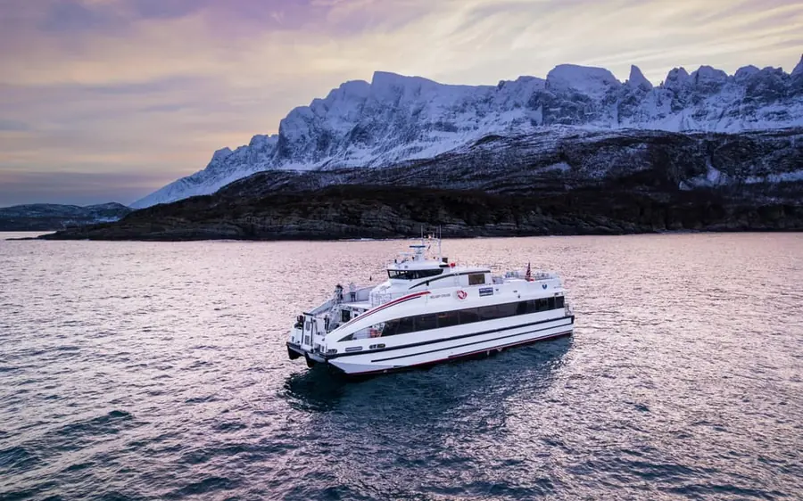 A fast catamaran in pink winter light